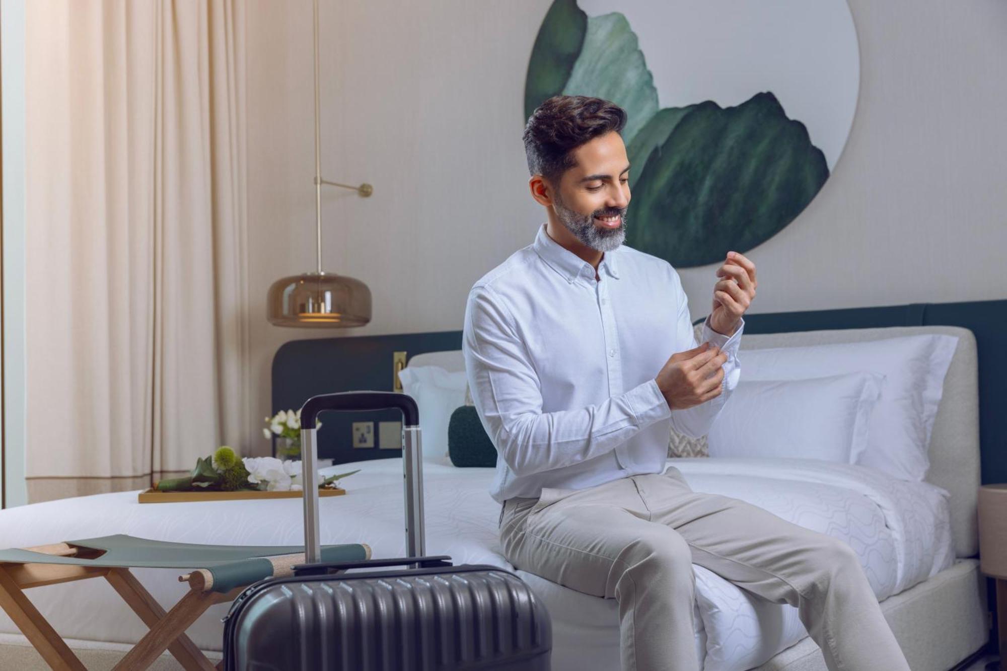 Onyx Rotana Hotel Manama Eksteriør billede A man using a mobile phone